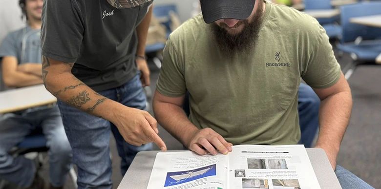 teacher pointing at welders book