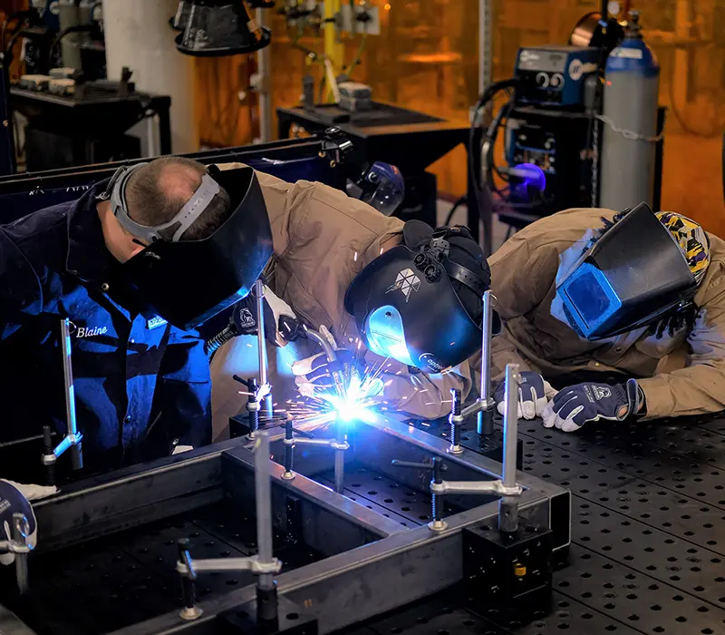 students working together on a weld