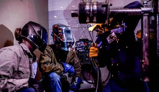 three people welding